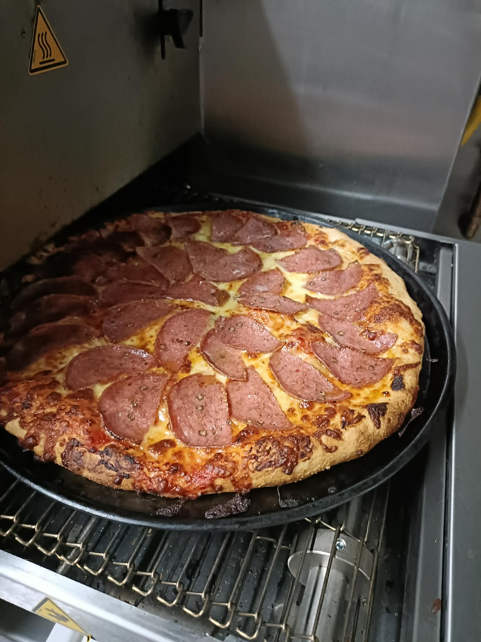 Fresh pepperoni pizza straight out of the oven at JOJO'S Pizza